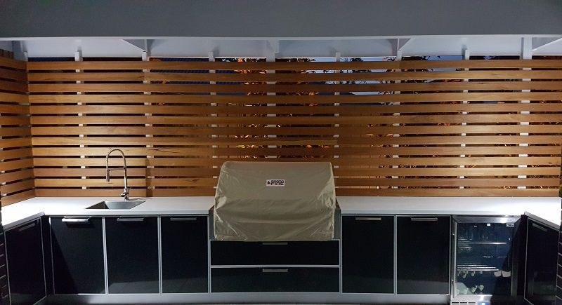 A Kitchen With a Grill and a Sink in Front of a Wooden Wall — Gunter Electrical In Kariong, NSW