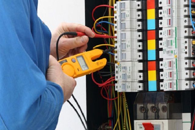 An Electrician is Working on an Electrical Box With a Clamp Meter — Gunter Electrical In Kariong, NSW