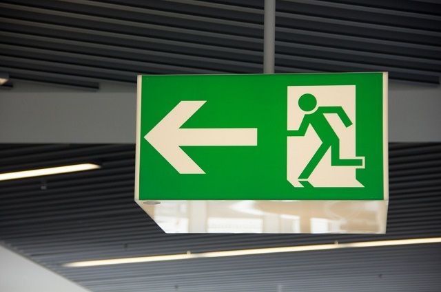 A Green Exit Sign With an Arrow Pointing to the Left — Gunter Electrical In Kariong, NSW