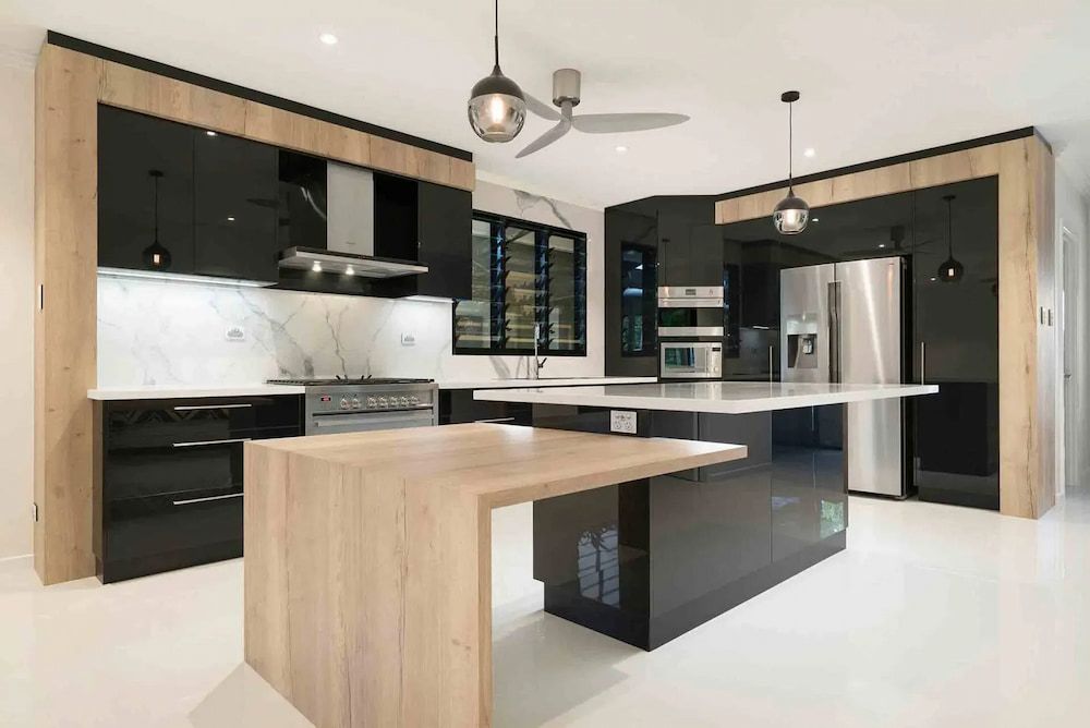 A kitchen with black cabinets and a wooden island — Designer Kitchens in Berrimah, NT