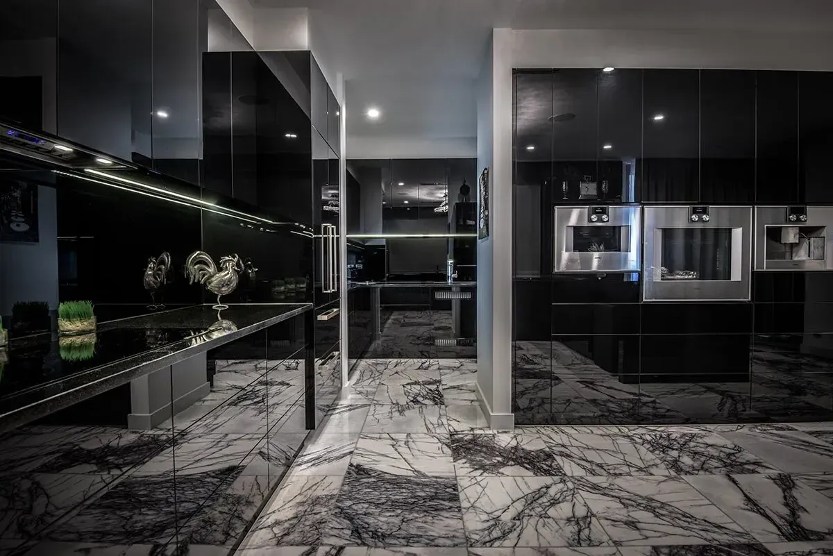 A Kitchen With Black Cabinets and a Marble Floor — Designer Kitchens in Berrimah, NT