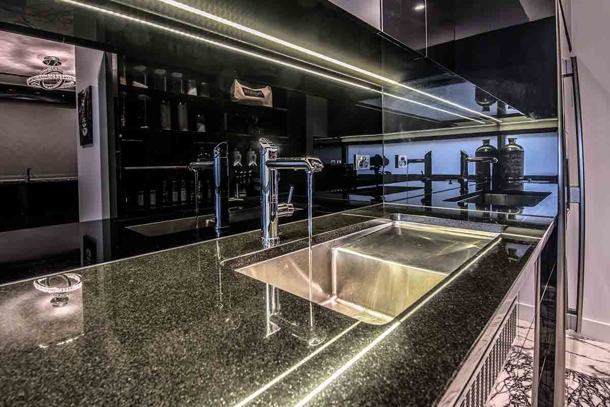 A Kitchen With a Stainless Steel Sink and a Black Counter Top — Designer Kitchens in Berrimah, NT