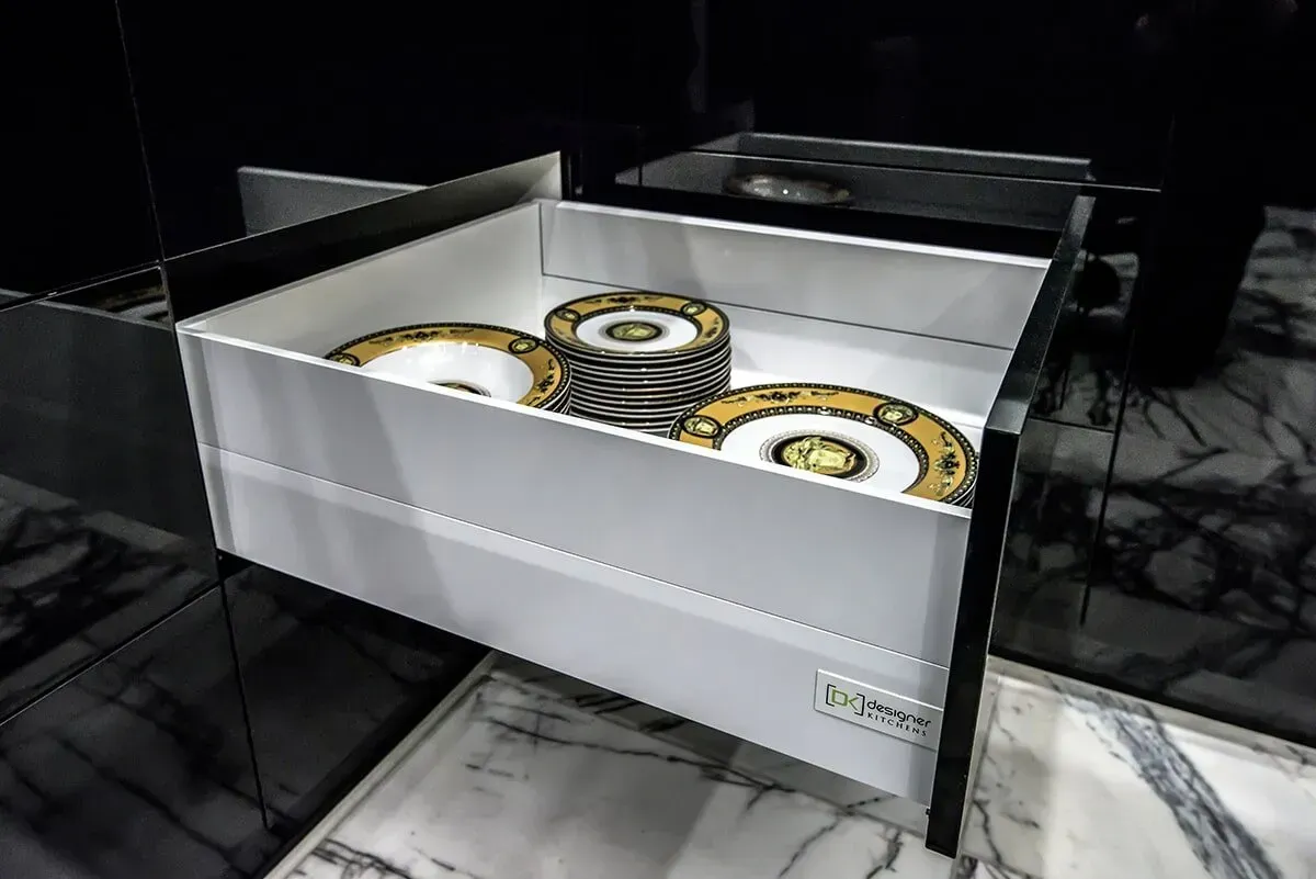 A White Drawer With Gold and White Plates in It — Designer Kitchens in Berrimah, NT
