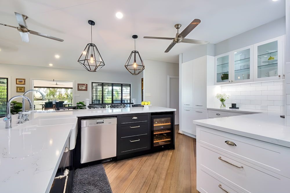 A Kitchen With a Large Island and a Ceiling Fan — Designer Kitchens in Berrimah, NT