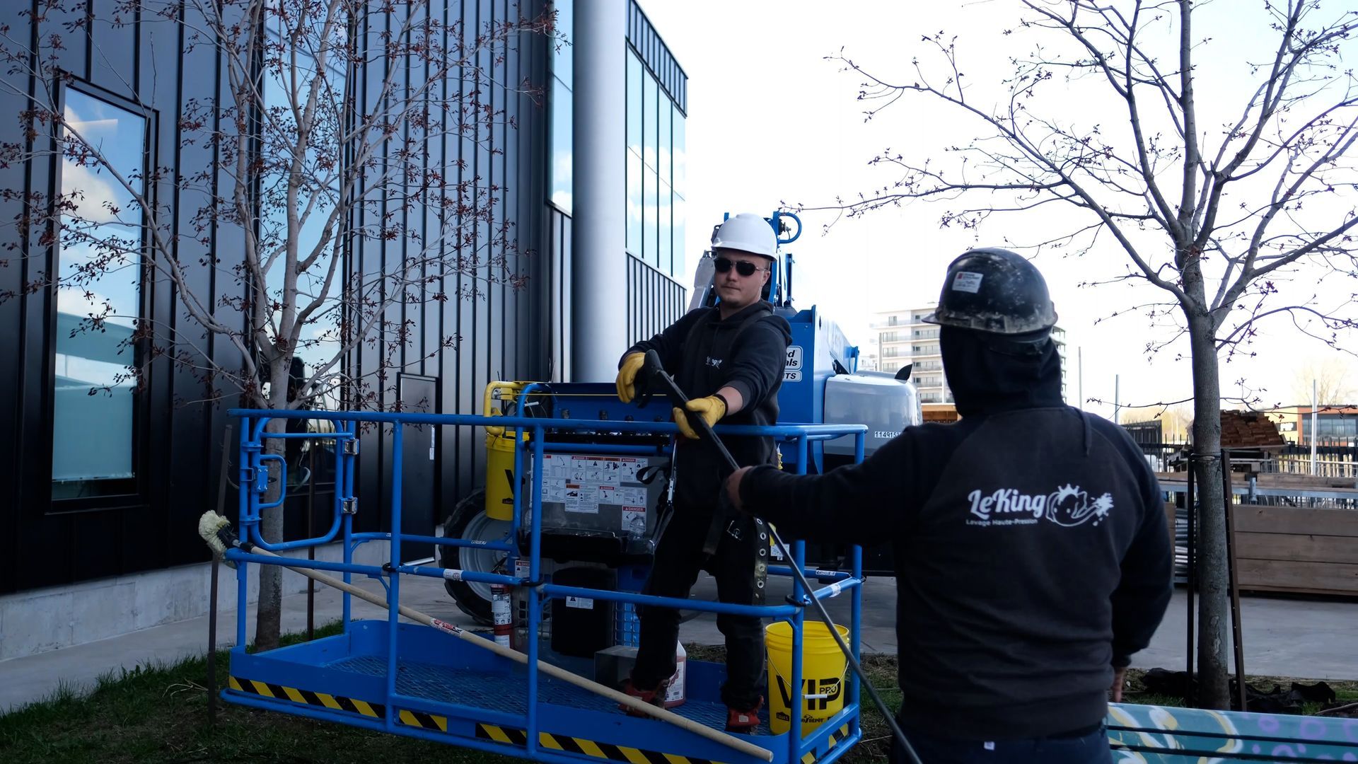 Un homme portant un casque de sécurité se tient à côté d’un homme dans une cage.