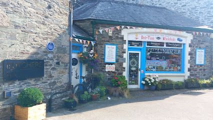 Shopfront with blue trim, flowers, and a sign