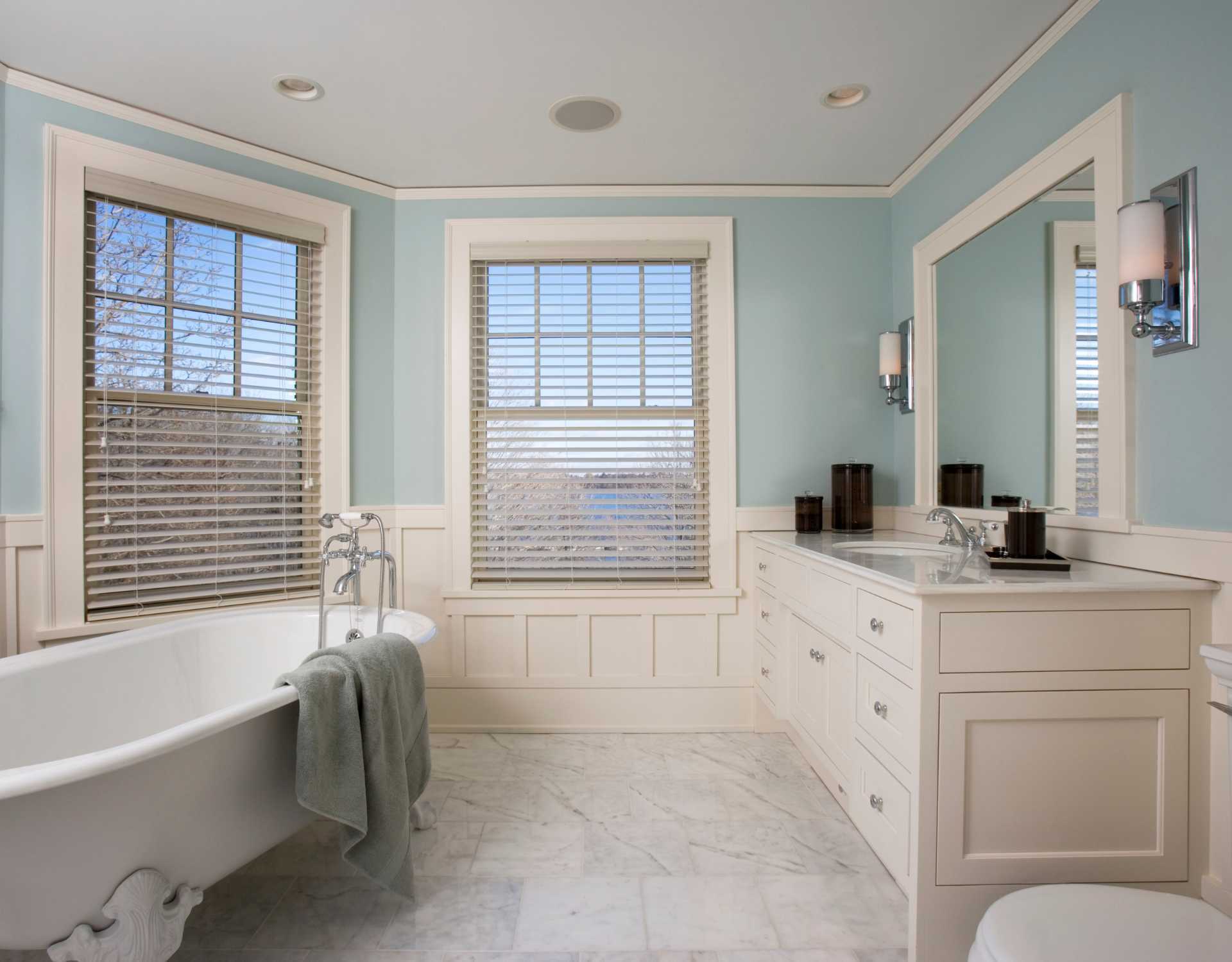 A bathroom with a tub a sink and a mirror