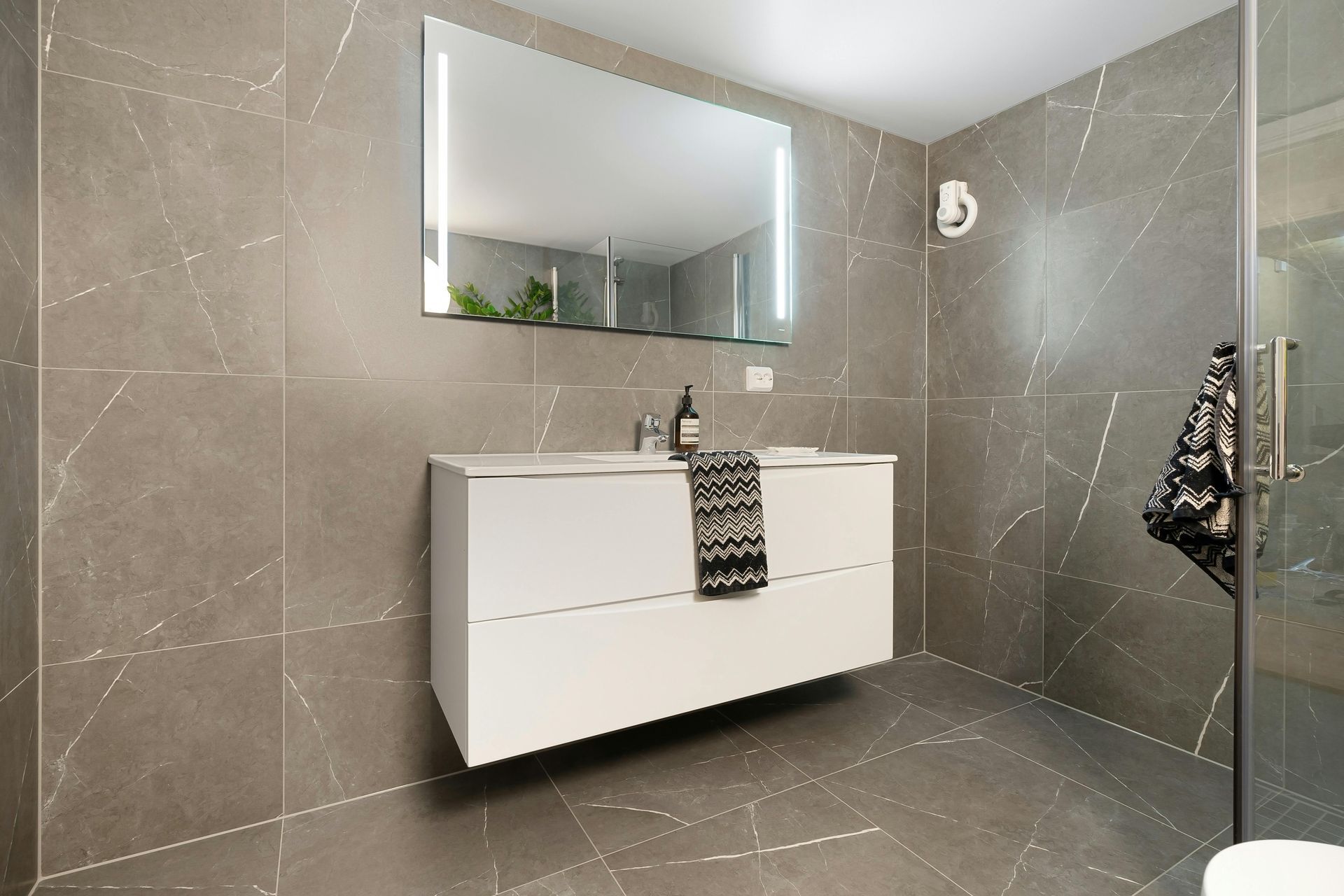 A bathroom with a sink , mirror and toilet.