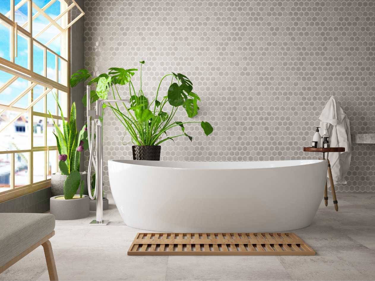 A bathroom with a tub , chair , plant and window.