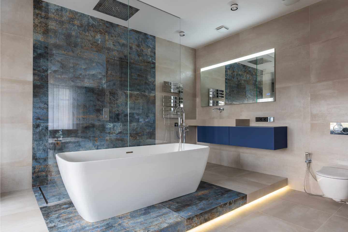 A bathroom with a bathtub , sink , mirror and walk in shower.