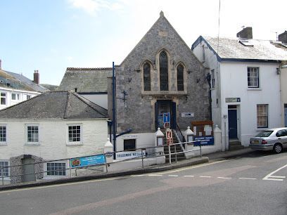 Stone church and white buildings on a street, sunny day.