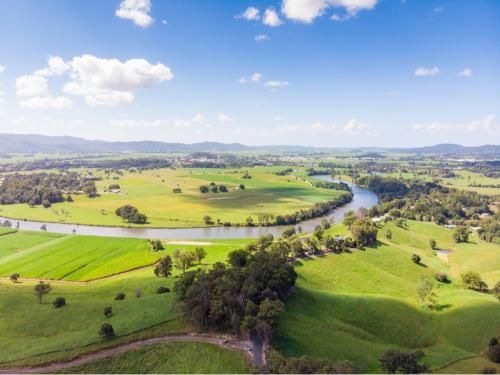 An Aerial View of a River Surrounded by Green Fields and Trees — Blind Outfitters in Smithfield, QLD
