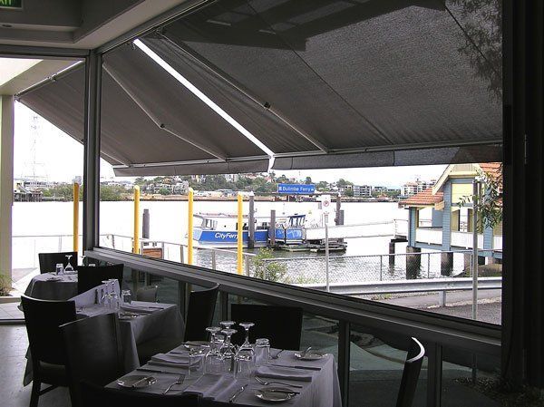 Restaurant With Tables and Chairs Overlooking a Body of Water — Blind Outfitters in Atherton, QLD