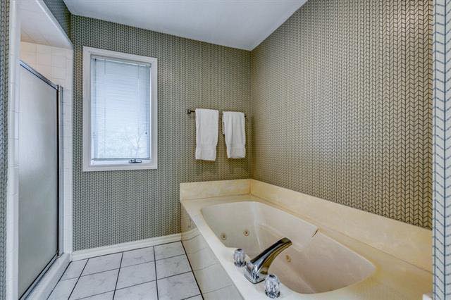 A bathroom with a jacuzzi tub and a window.