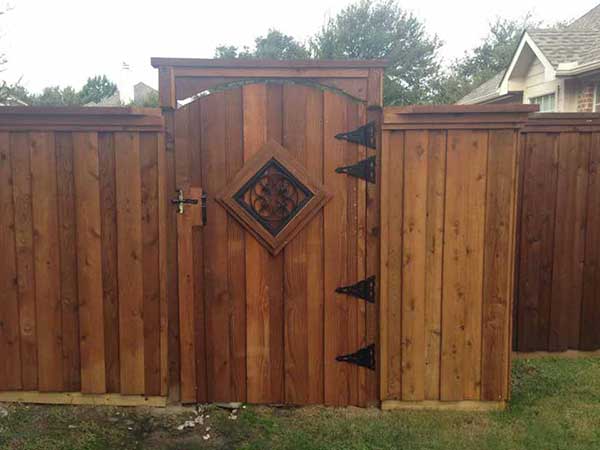 A wooden fence with a gate in the middle of it.