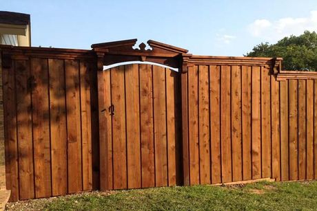 A wooden fence with a gate in the backyard.