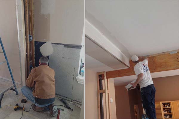 A man is kneeling down in a room and painting the ceiling.