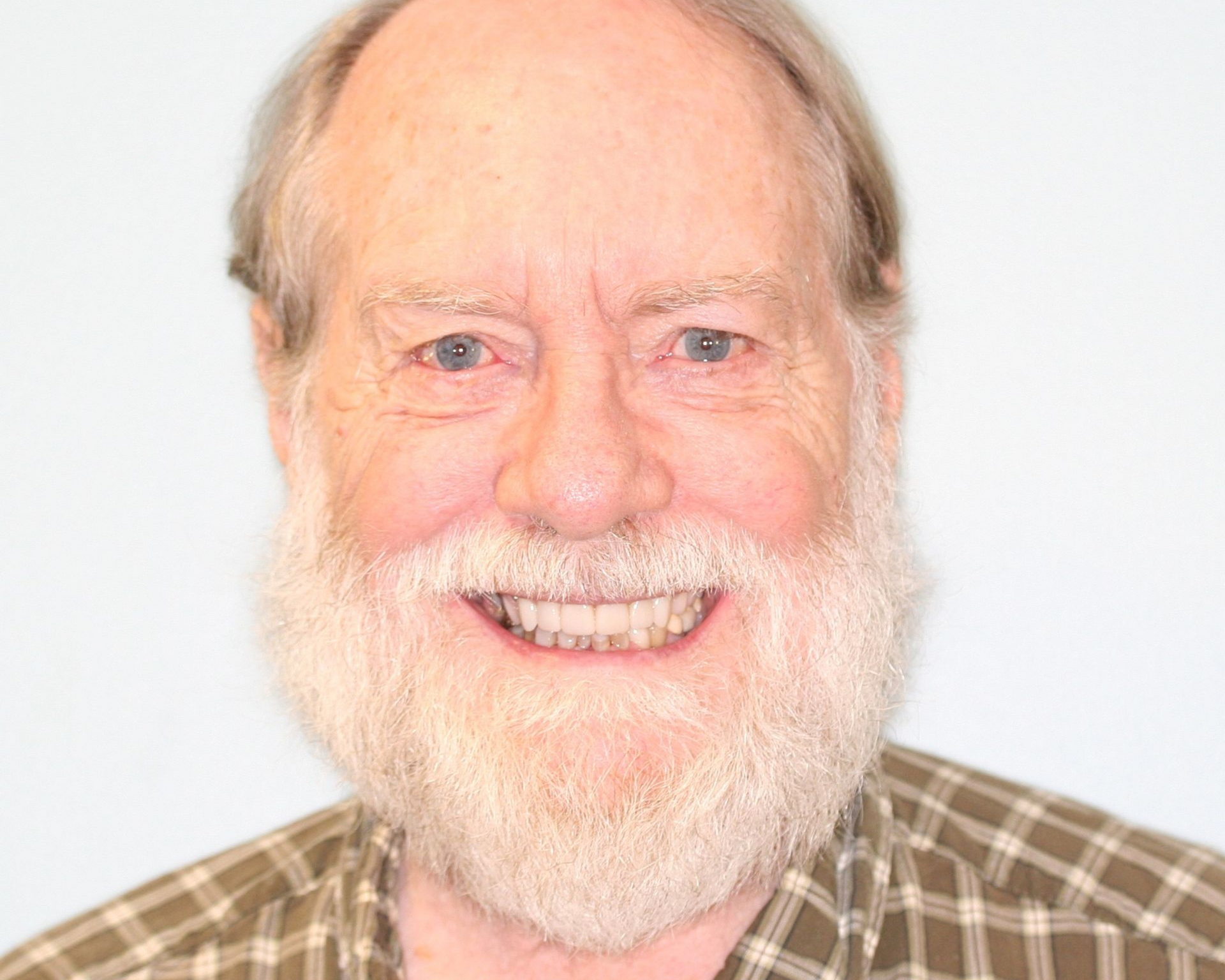 Woman with blue eyes, smiling, light brown hair, visible teeth.