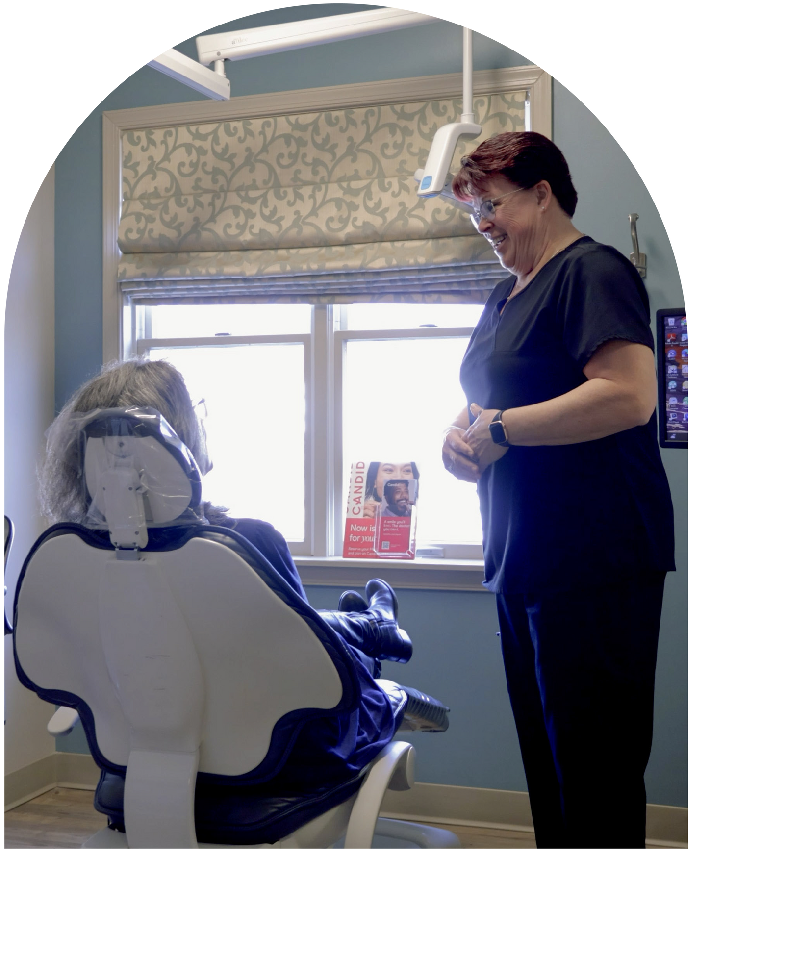 Hygienist in blue scrubs receiving an ID card, smiling in Hunt Valley, Maryland 21030.