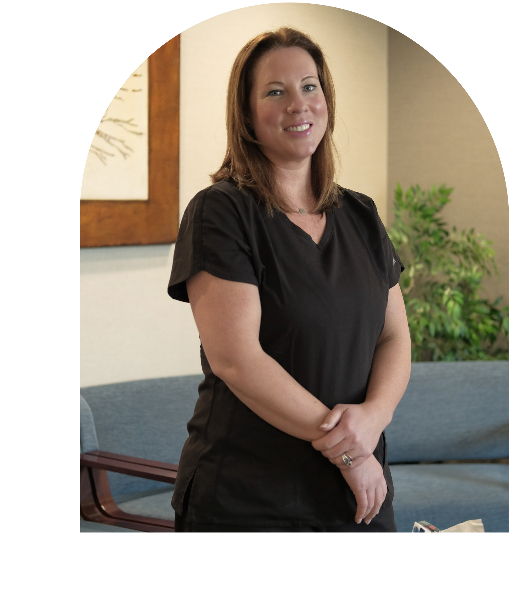 Dr. Vail in white coat smiles, light blue top, in front of a blue background.