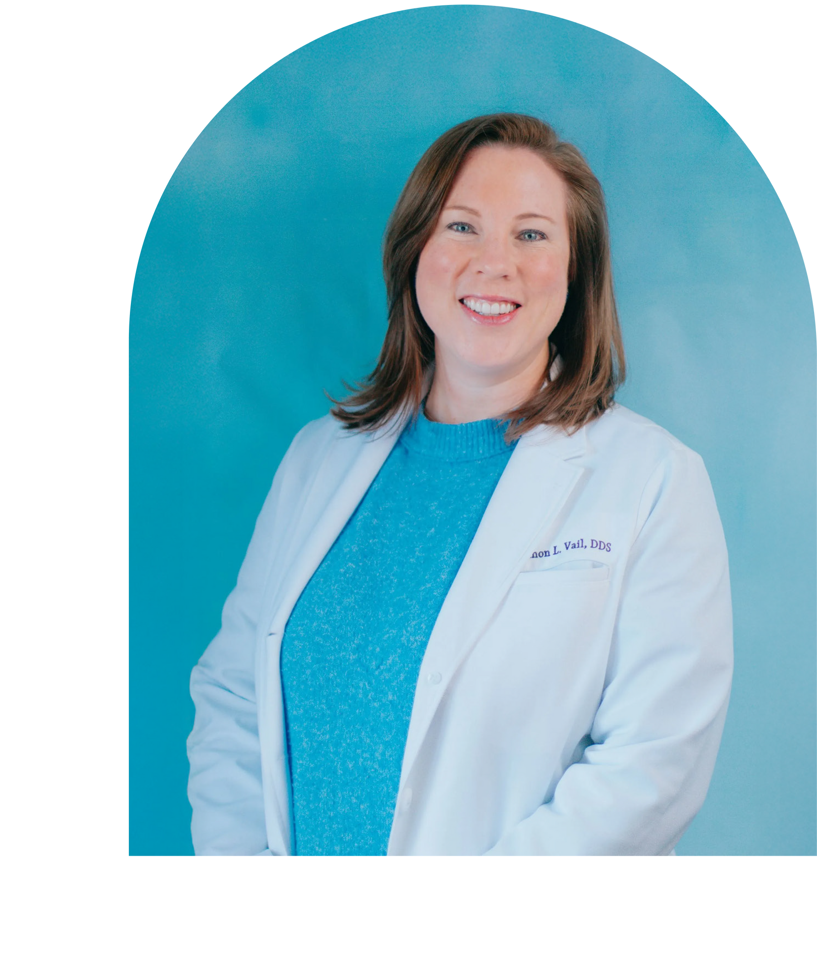 Dr. Vail in white coat smiles, light blue top, in front of a blue background.