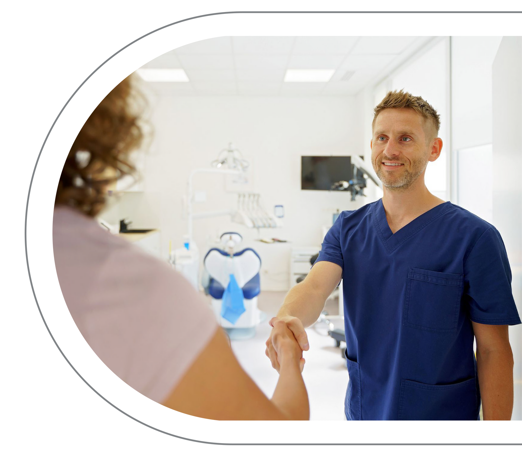 Dentist shaking hands with a patient in a dental office. Both are smiling.