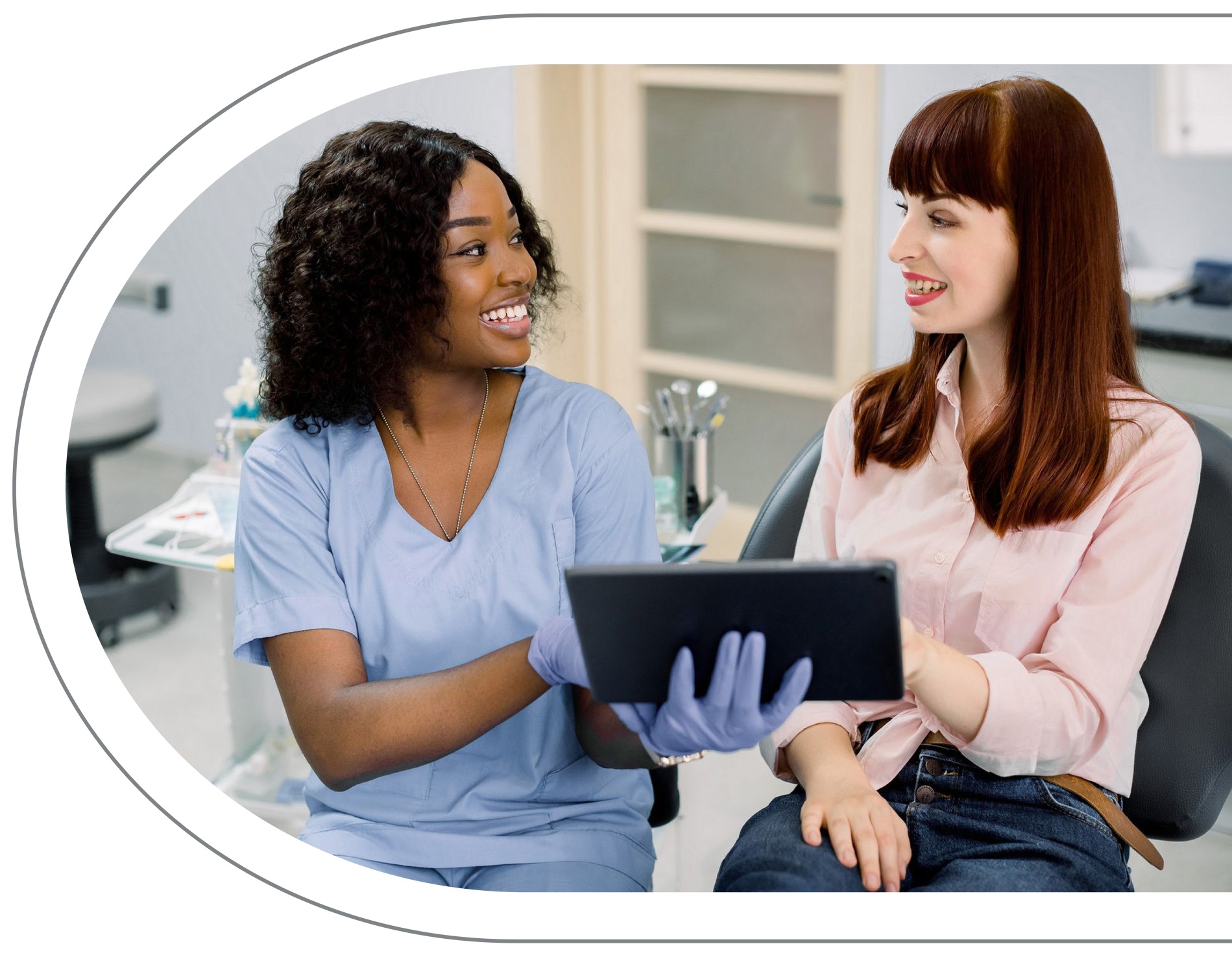 Dental professional with patient, reviewing tablet. Both smiling, at Vail Dental Associates in Hunt Valley, MD, 21030..