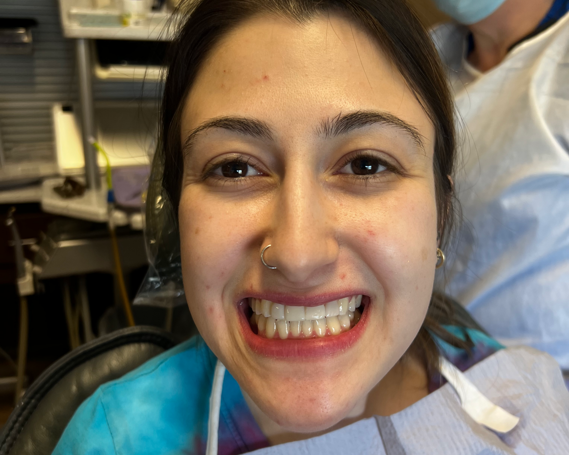 Woman with blue eyes, smiling, light brown hair, visible teeth.