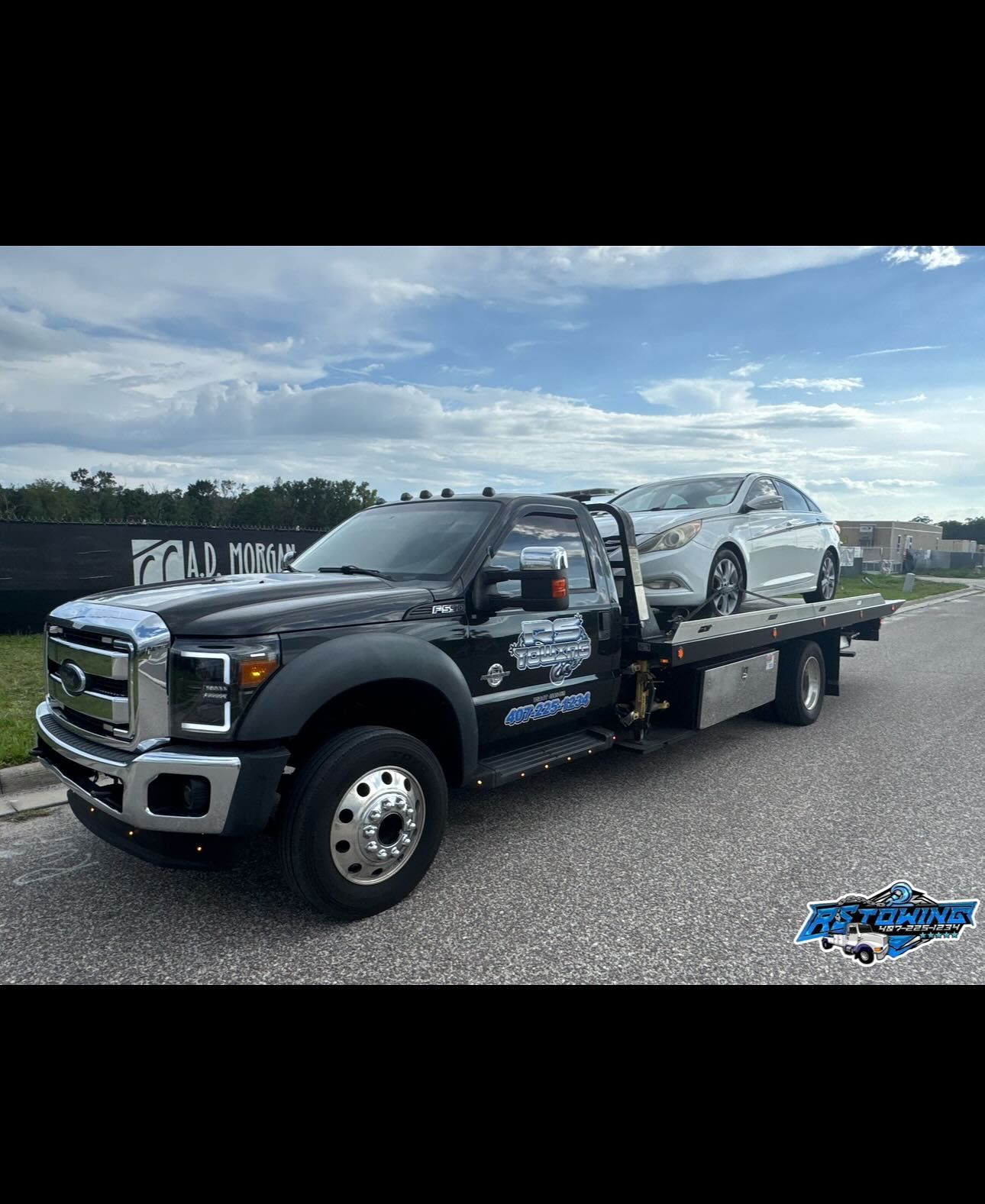 A tow truck with a car on the back of it.