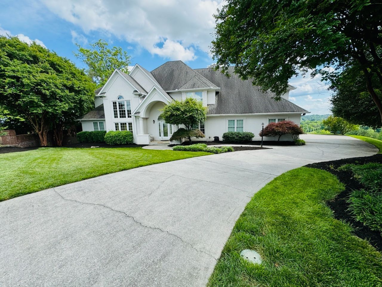 A large white house with a driveway leading to it