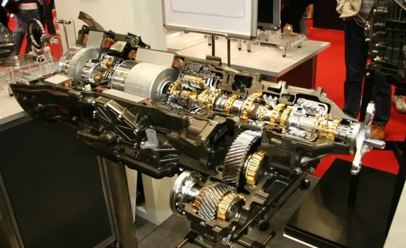 Cutaway view of a complex automotive transmission, showcasing internal gears and components.