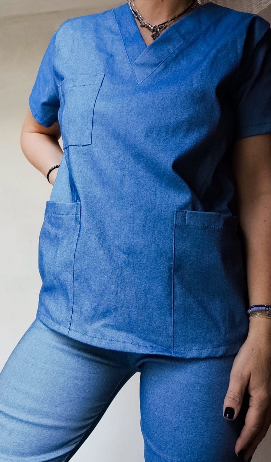 Persona que viste una camiseta y pantalones vaqueros; con las manos en los bolsillos.