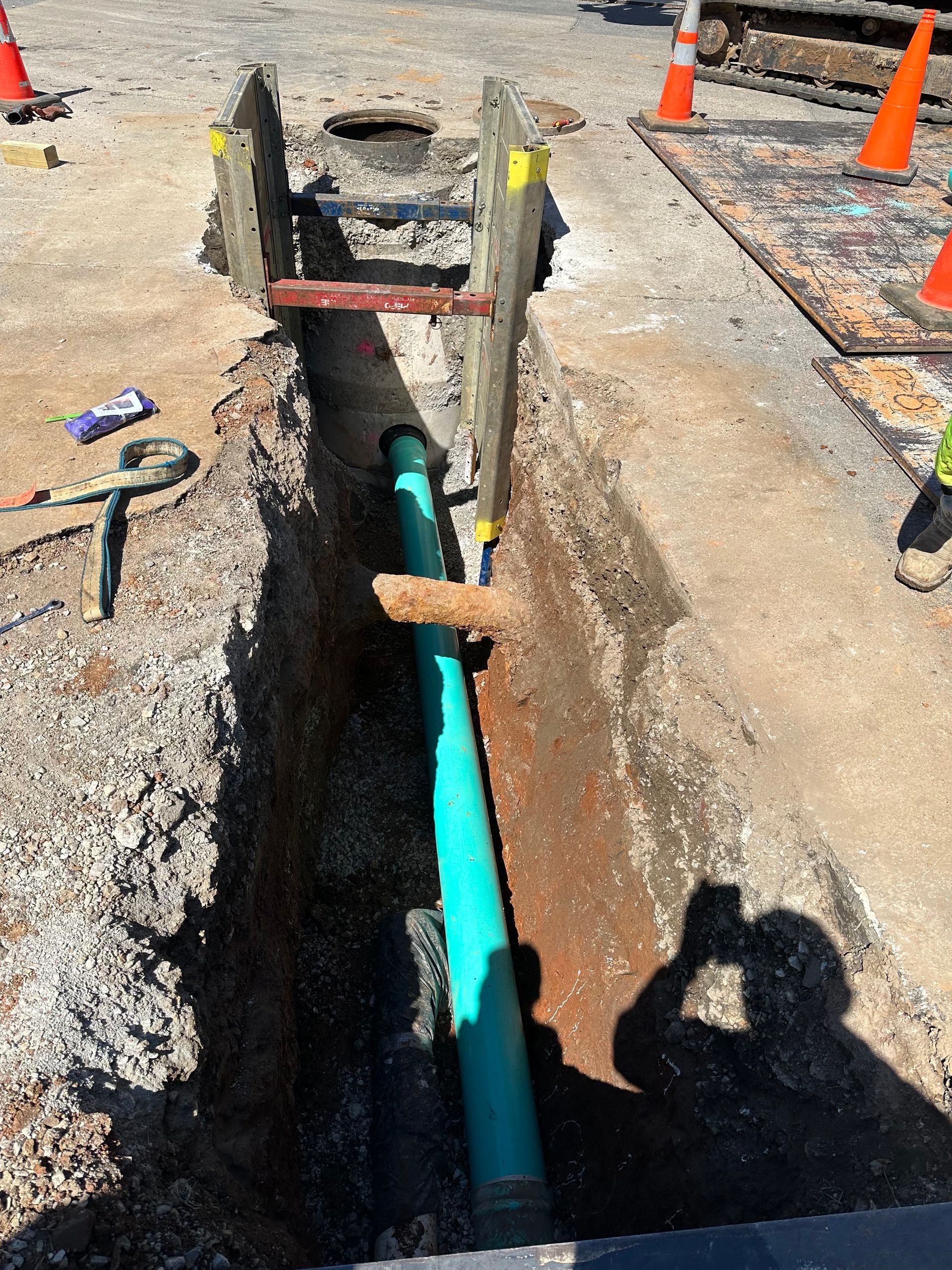 A copper pipe is sticking out of the ground in a puddle of water.