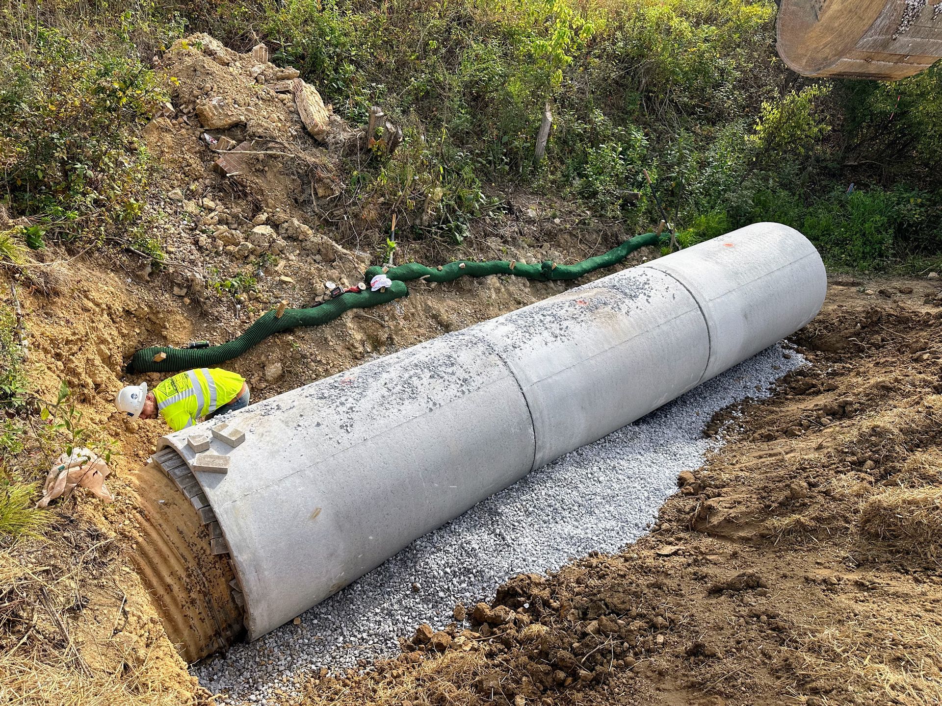 A pile of rocks is sitting in the dirt in front of a building.