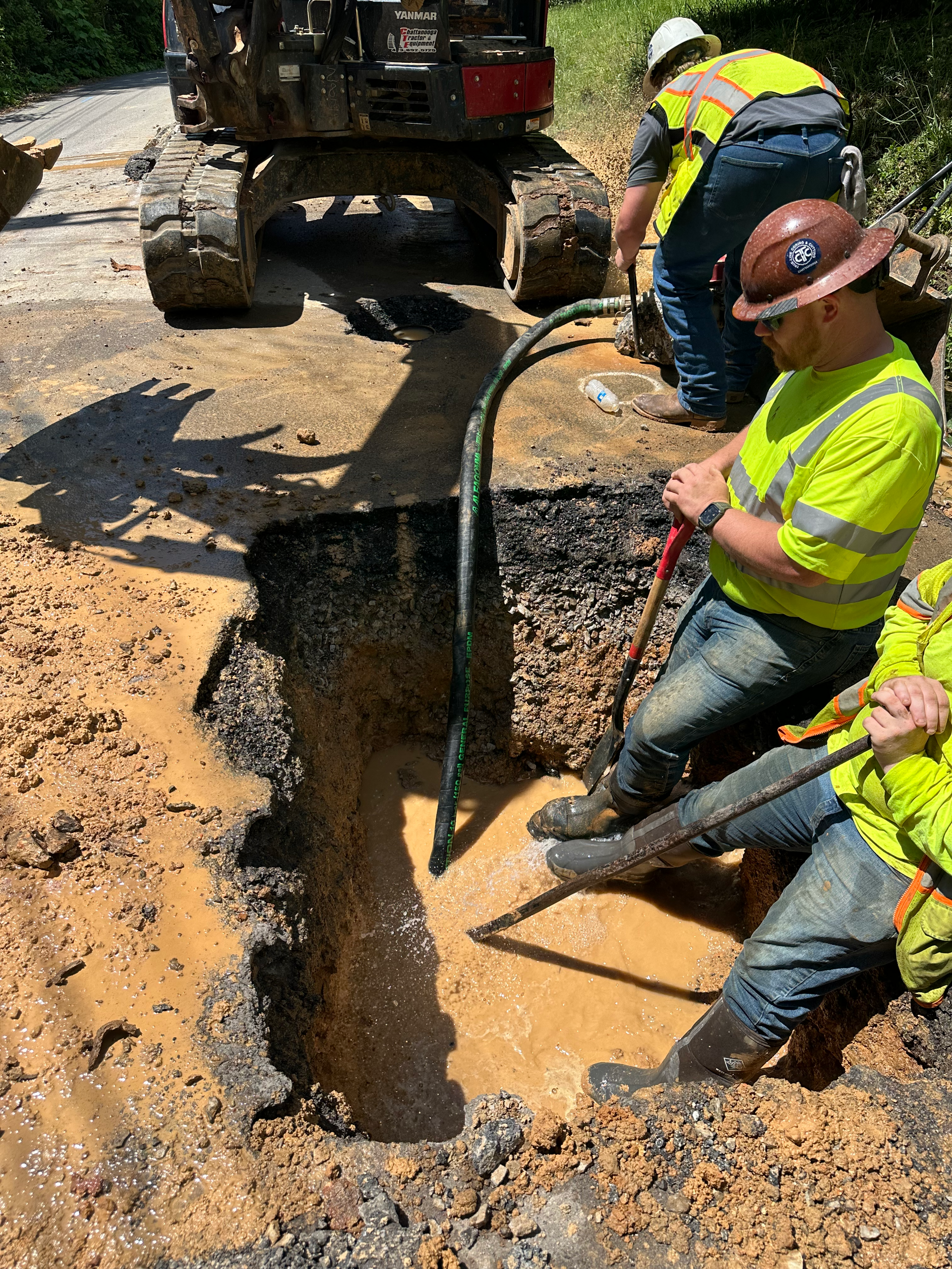 A toolbox is sitting on top of a pile of dirt next to a hole in the ground.
