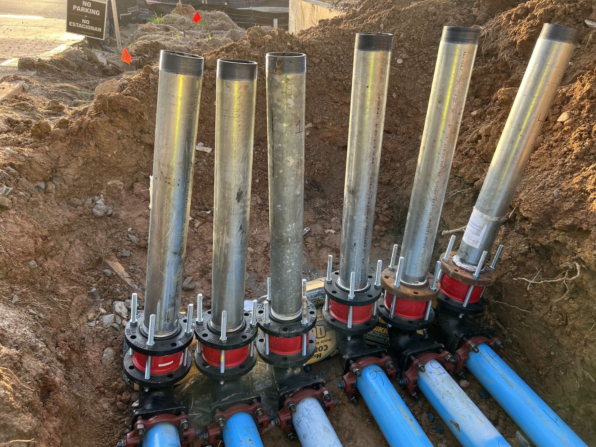 A bunch of pipes are laying in the dirt