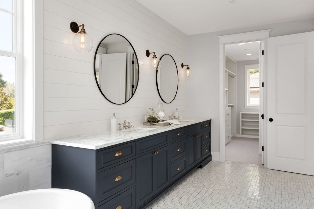 Bathroom With Navy Blue Vanity, White Marble Countertop, Oval Mirrors — Carl Whelan Building & Renovations In Wyong, NSW
