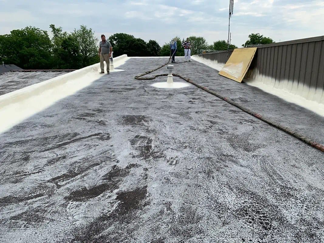 A couple of men are standing on top of a roof.