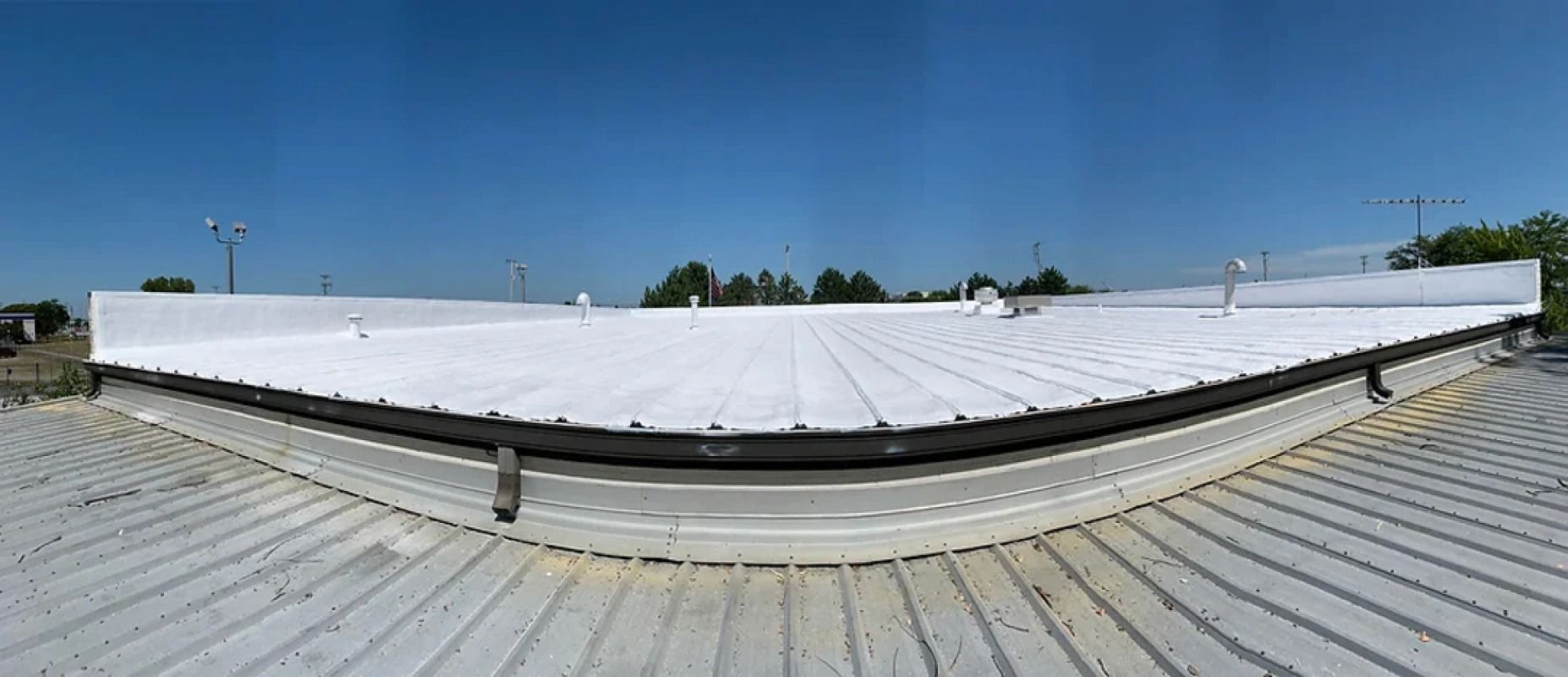 A large white roof with a blue sky in the background.