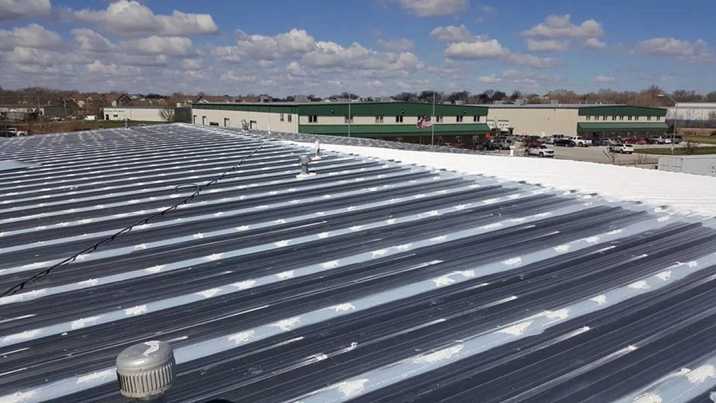 A roof with a lot of white stripes on it and a building in the background.