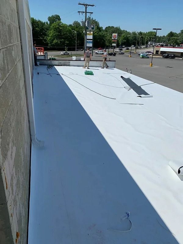 A white roof is being installed in a parking lot