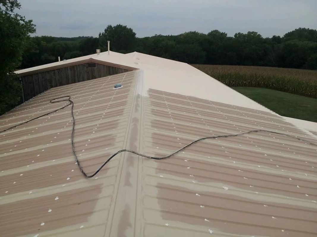 A roof with a hose attached to it and a field in the background.