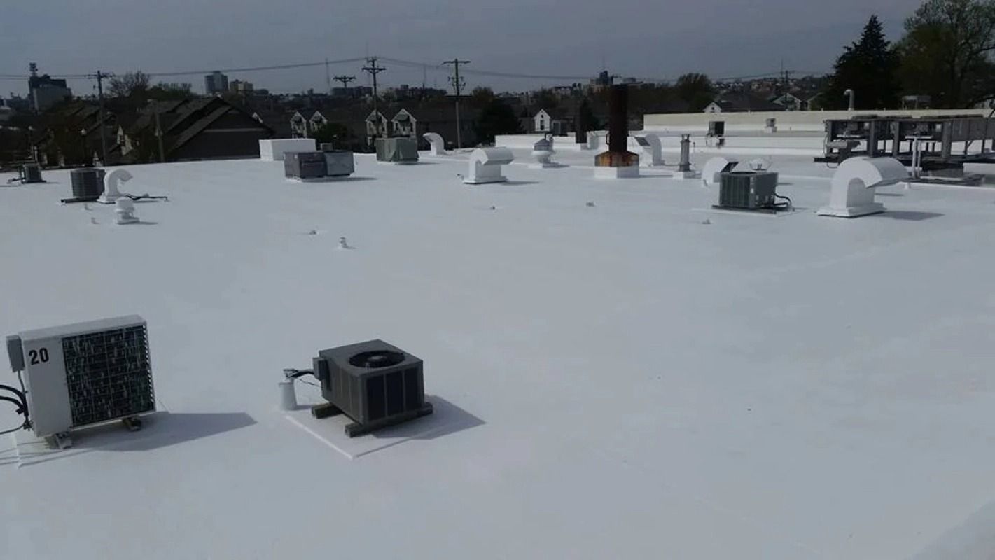 A white roof with a lot of air conditioners on it.