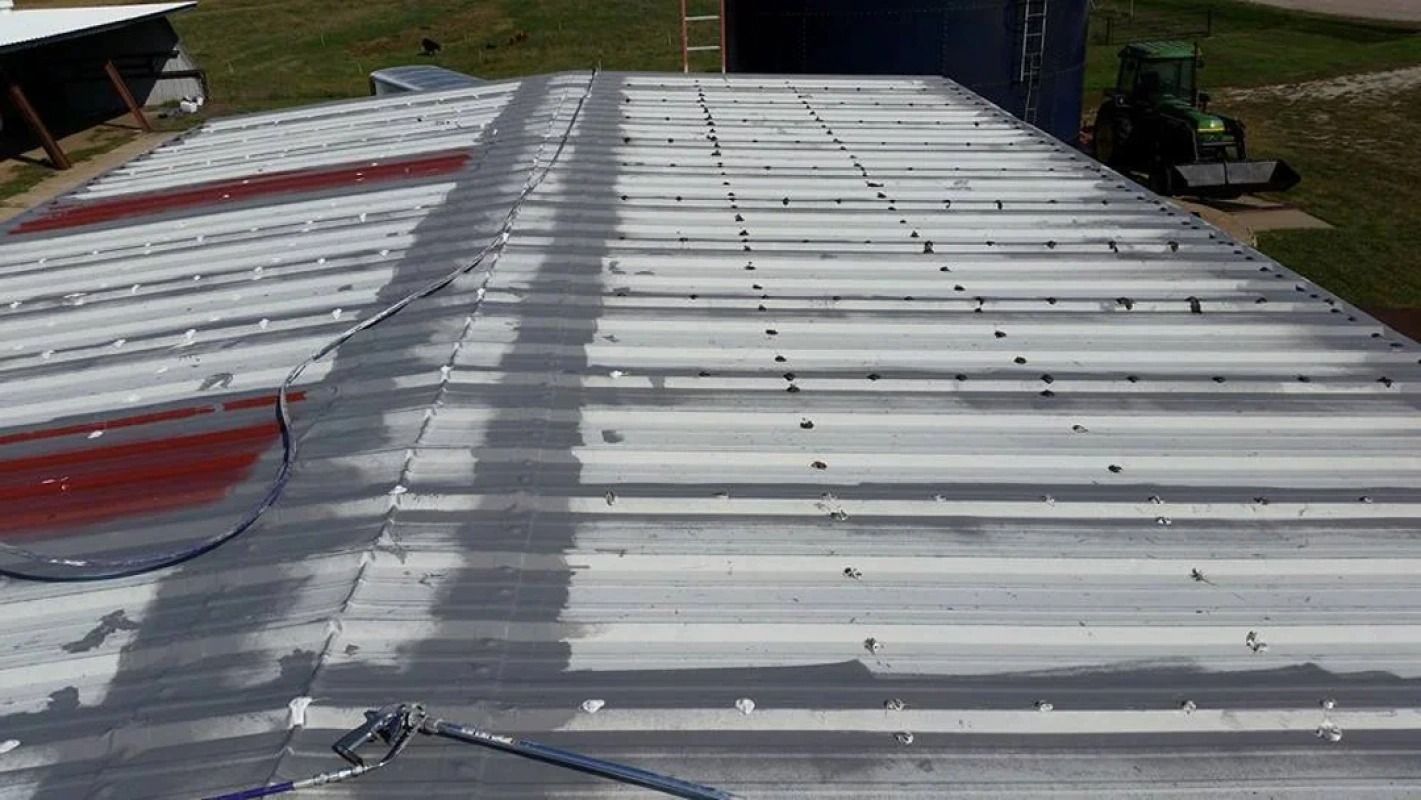 The roof of a building is being painted white.