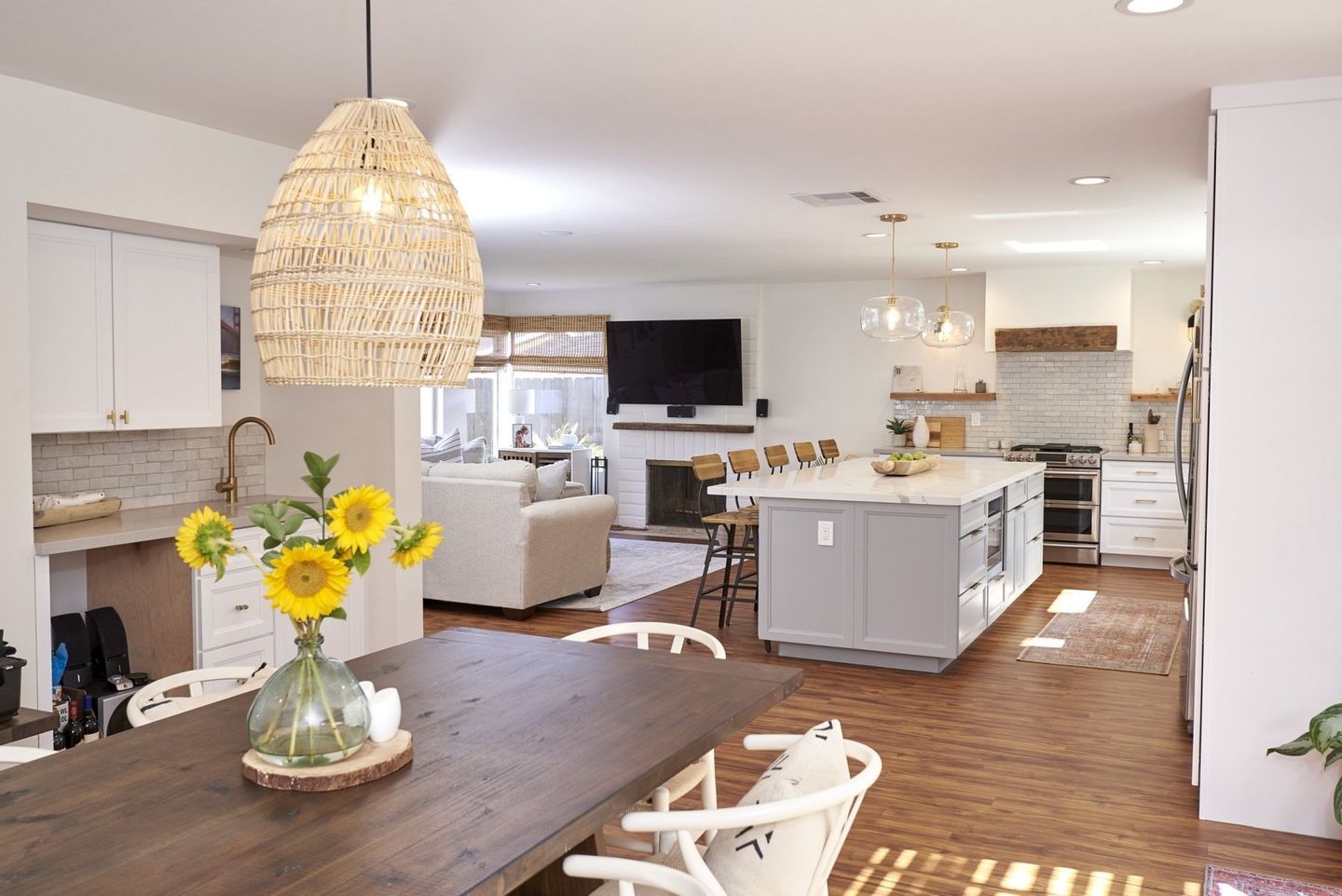 A dining room table with a vase of sunflowers on it