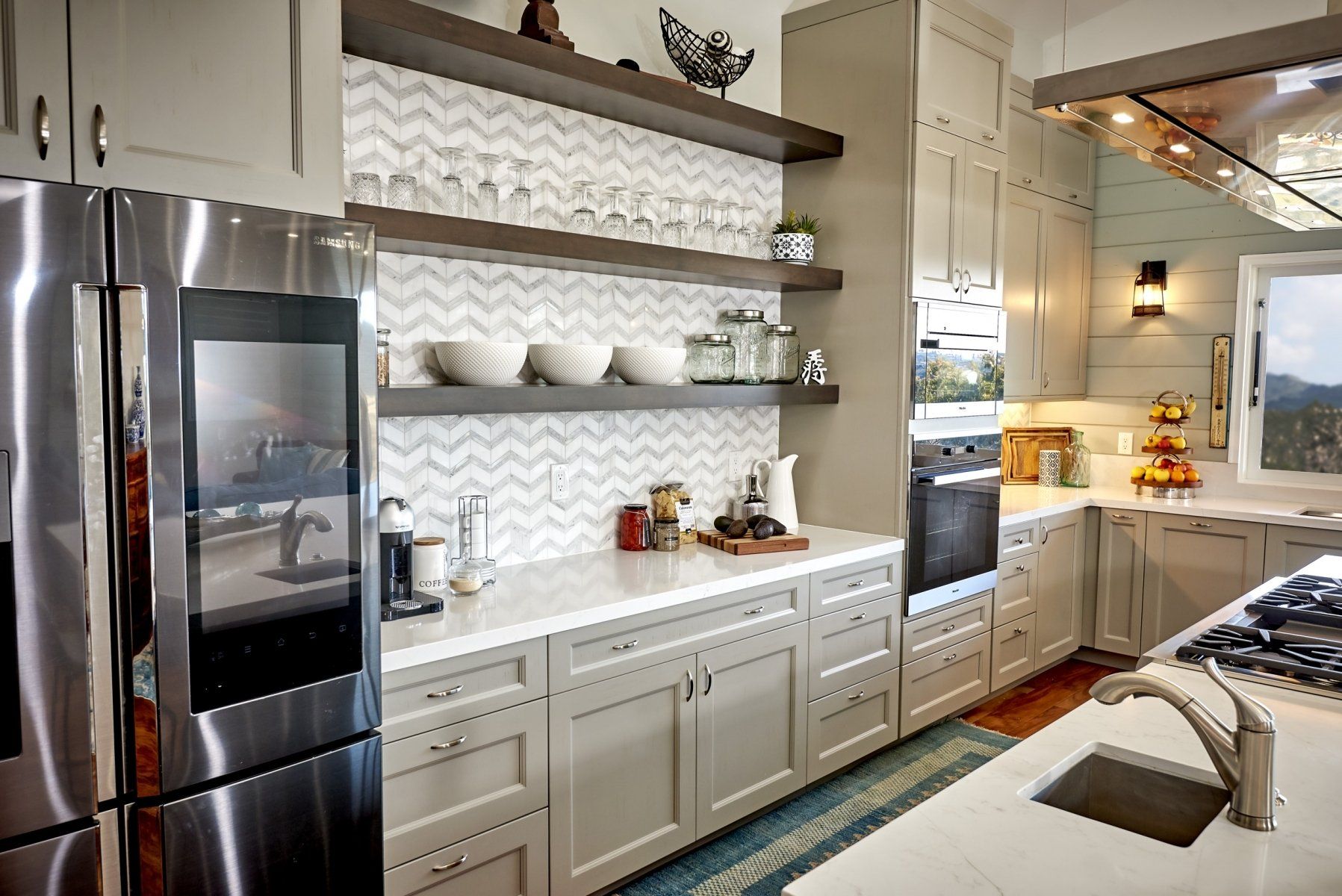 a kitchen with stainless steel appliances and white cabinets by remcon design build