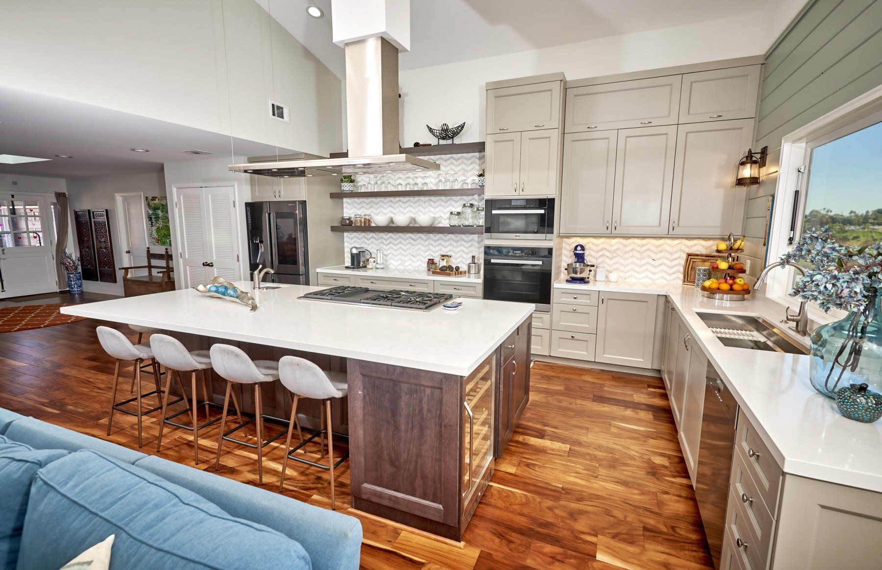 a kitchen with white cabinets and stainless steel appliances by Remcon