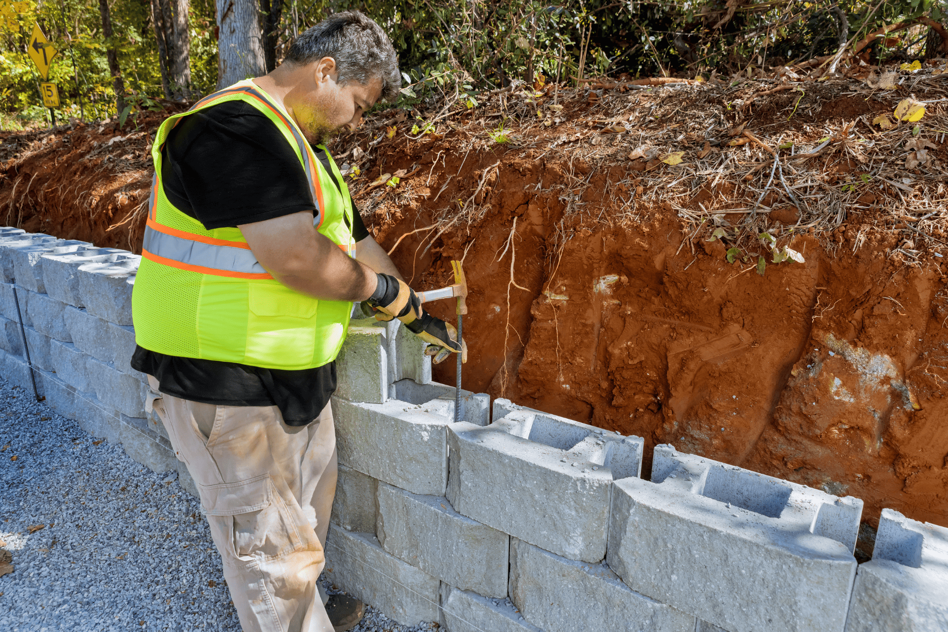 Professional Landscaper From Richmond Landscapes Building Retaining Walls Using A Hammer