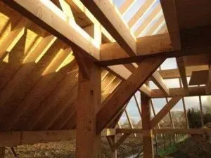 Omhoog kijkend naar het plafond van een houten gebouw in aanbouw.