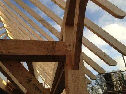 Het dak van een gebouw wordt gebouwd met houten balken.